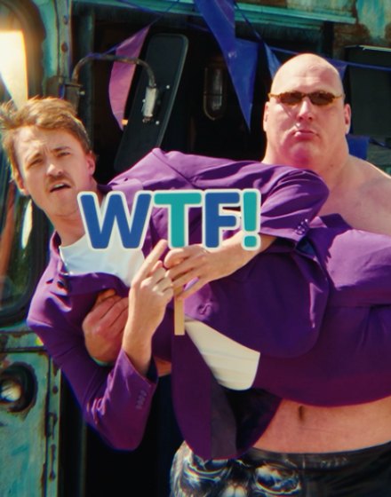 Tikkie activation: a man in a purple suit is carried by a big shirtless man holding a WTF! sign