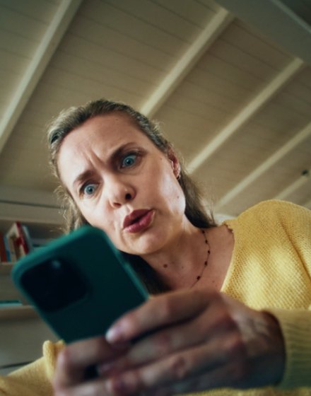 ABN AMRO online campaign: a woman in a yellow cardigan looks at her phone in disbelief